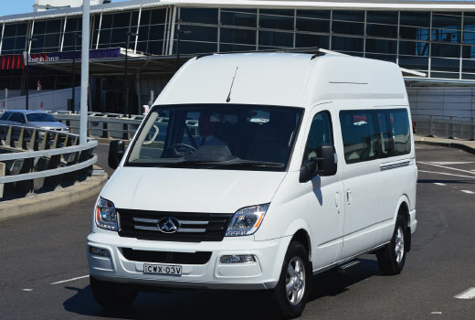 Reliable white 1 to 3-ton vans driving through a busy airport area, perfect for city transport, airport transfers, and everyday commercial use across major UAE metro regions.